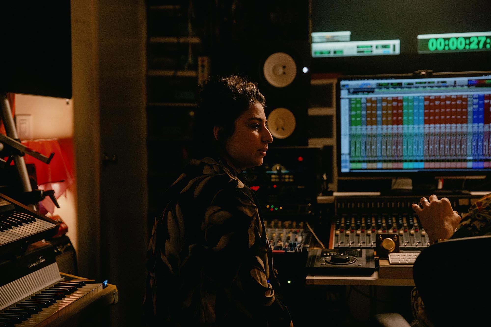 Arooj Aftab sitting in a recording studio booth.