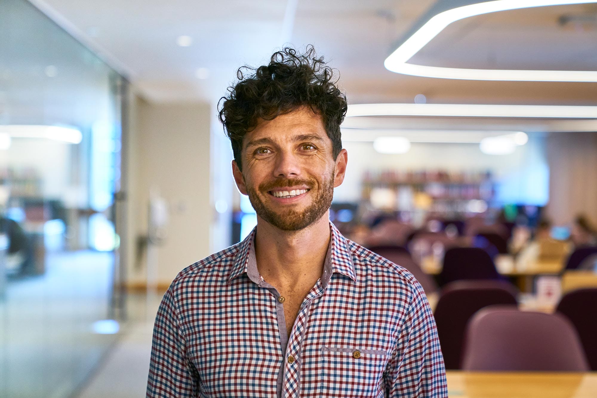 Edward Chouchani smiling in a library center.