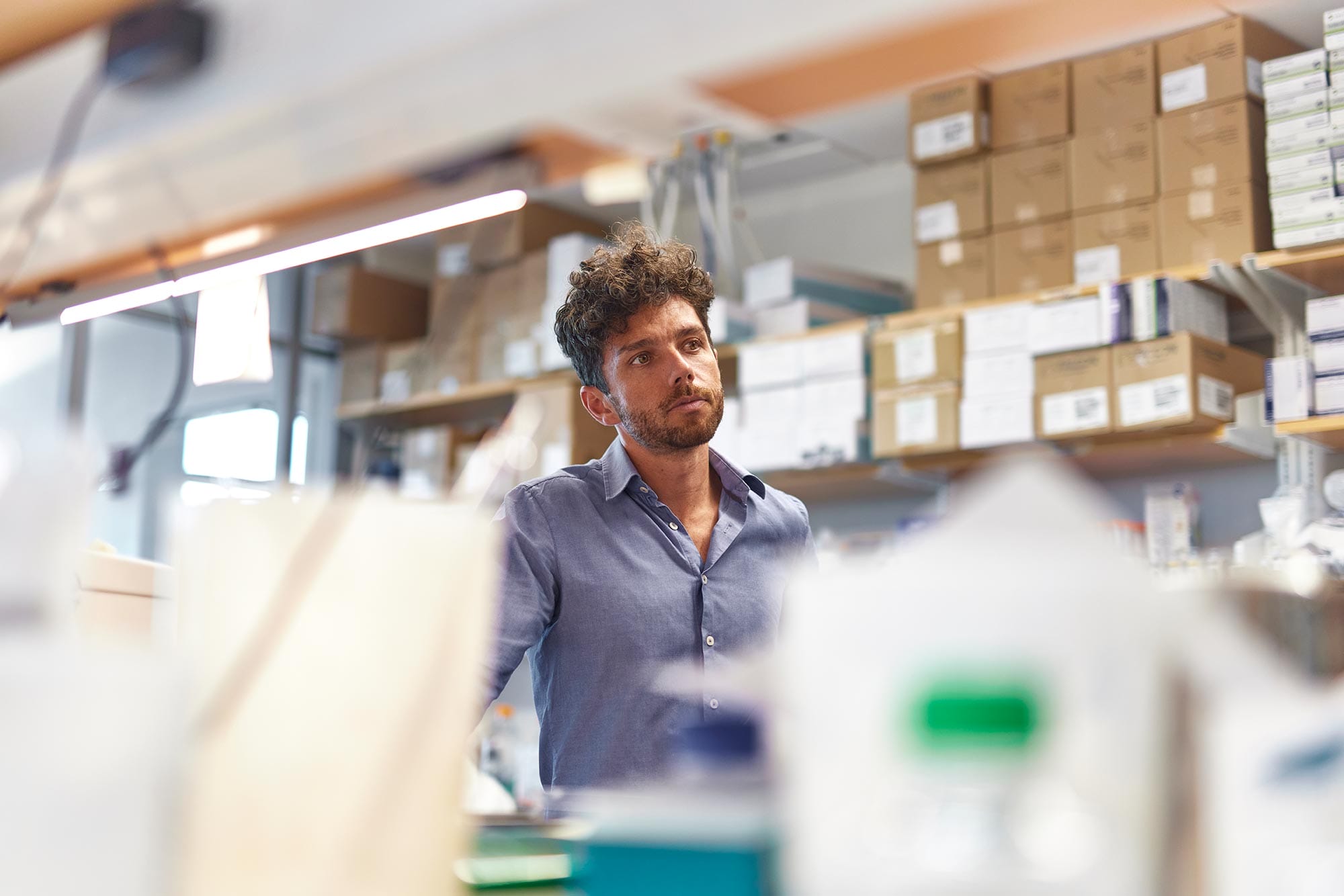 Edward Chouchani stands in a lab surrounded by equipment.