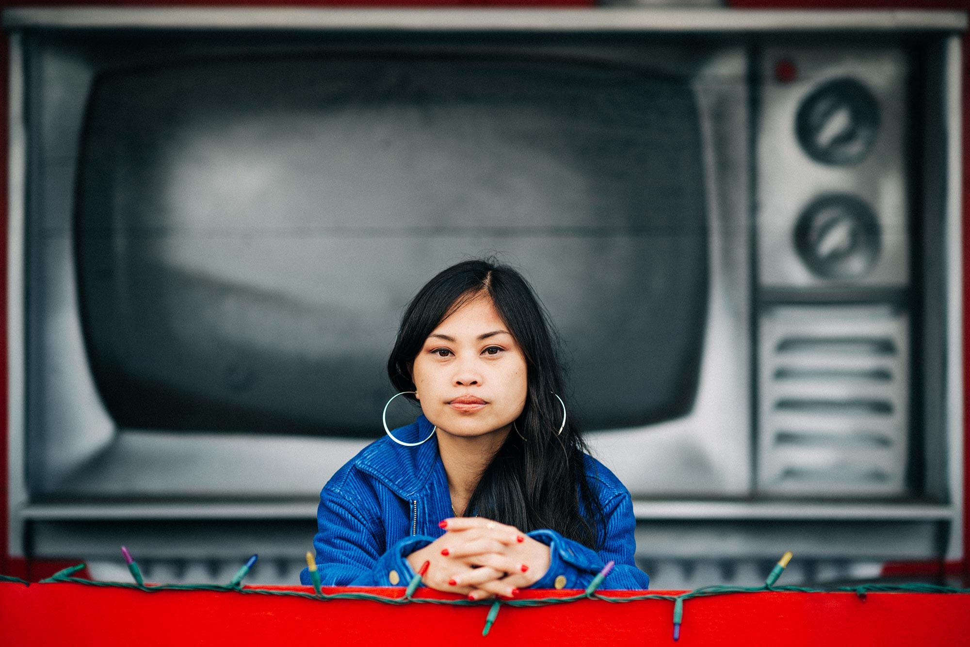 Ruby Ibarra leaning on red fence.