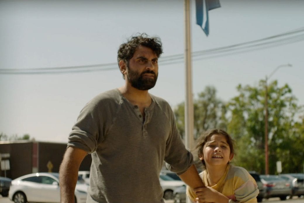 Truck driver, Kiran standing in a parking lot while a young girl pleads with him.
