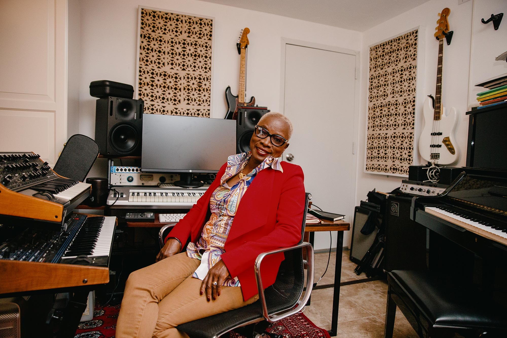 Angélique Kidjo sitting at a studio desk with musical equipment.