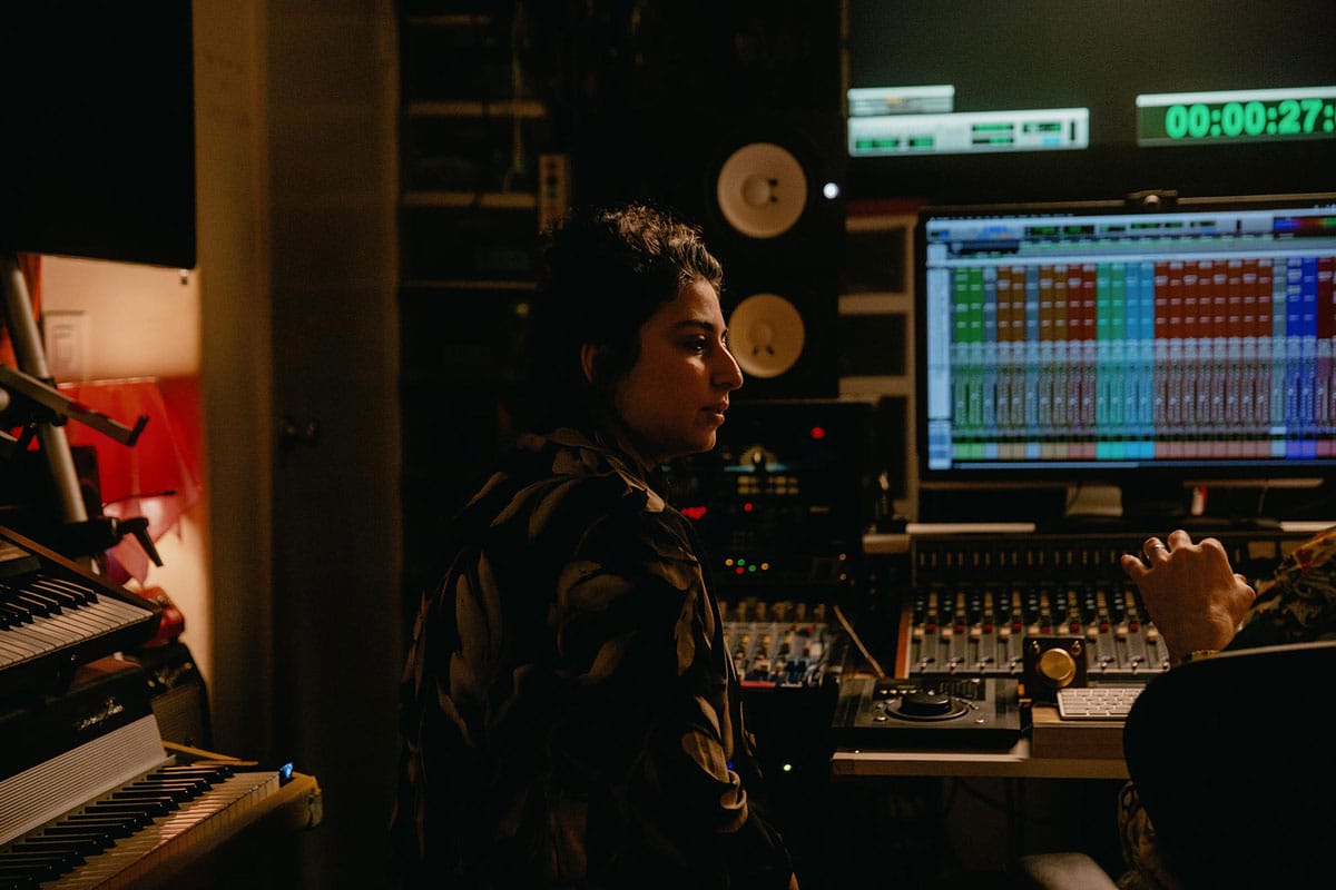 A side-profile of Arooj Aftab in a recording studio.