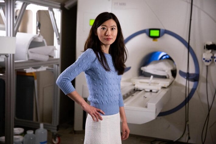 A portrait of Biyu J. He in front of an MRI machine.