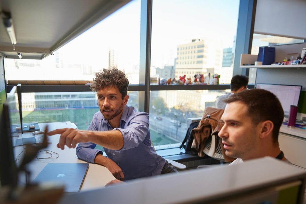 Edward Chouchani and a colleague working together at a desk in the lab.