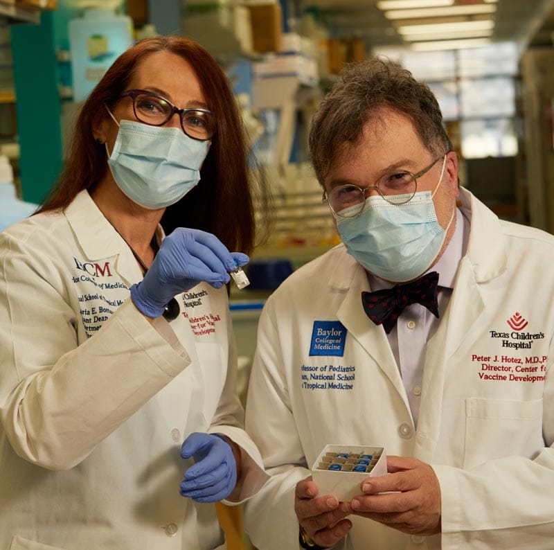 Dr. Maria Elena Bottazzi and a colleague pose with a vaccine sample.