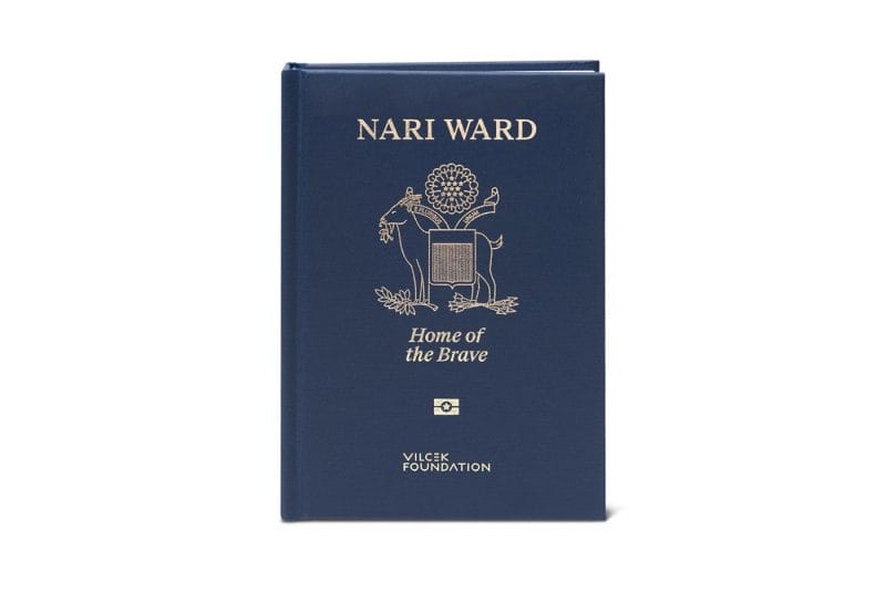 A navy hardcover book with gold text and a emblem with a goat.
