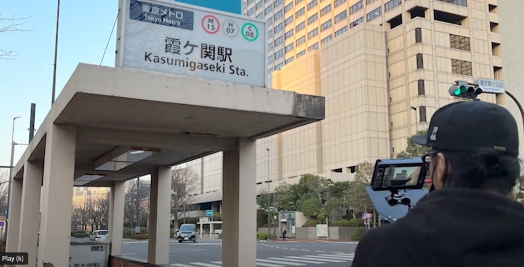 A cinematographer films a metro train station entrance in Tokyo, Japan.