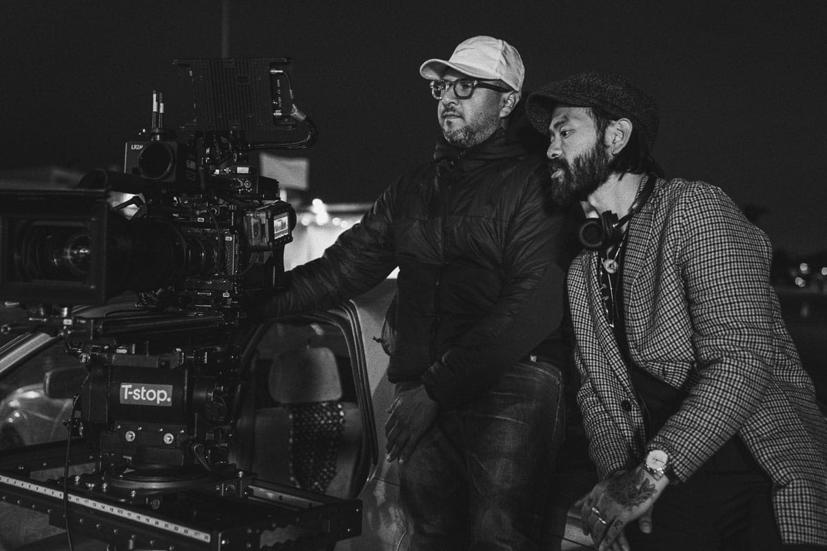 Sing J. Lee and the film's cinematographer seated behind the camera.