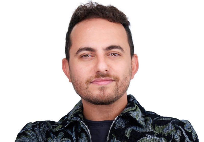 A portrait of Wael Morcos wearing a dark patterned jacket.
