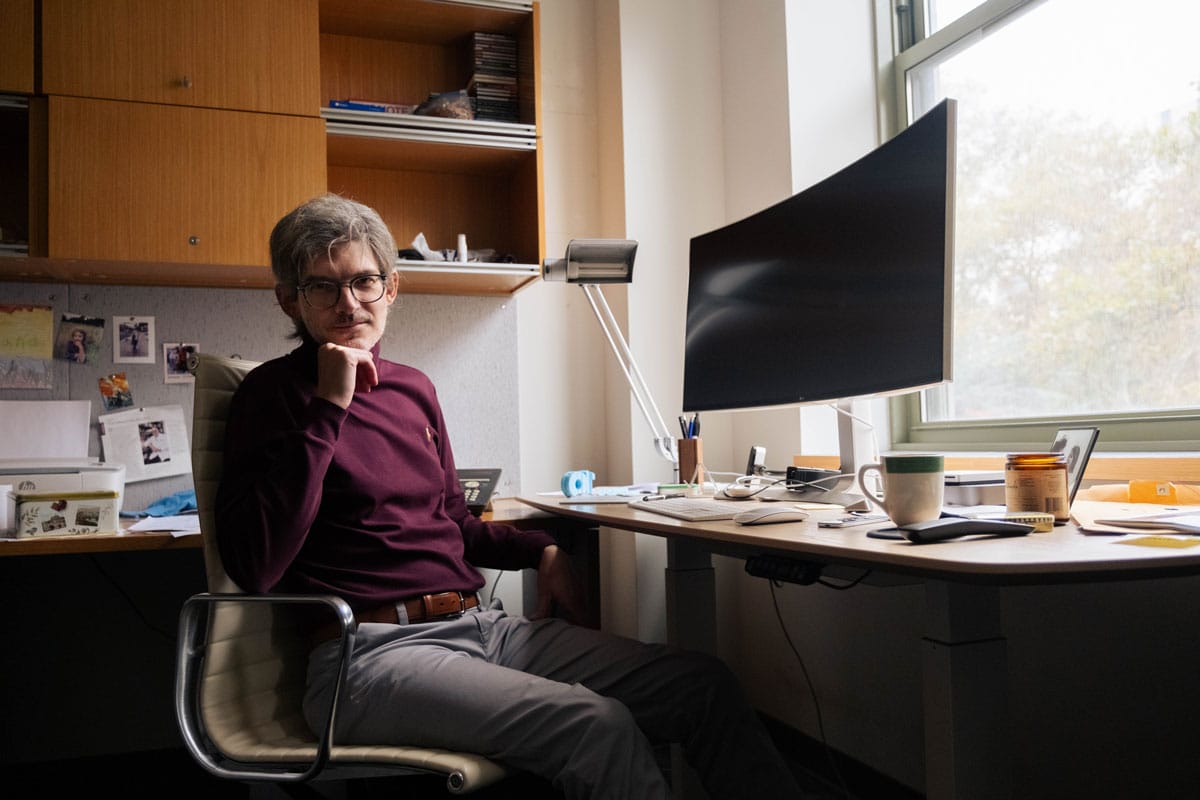 Luciano Marraffini sitting at his desk in front of the computer in his office.