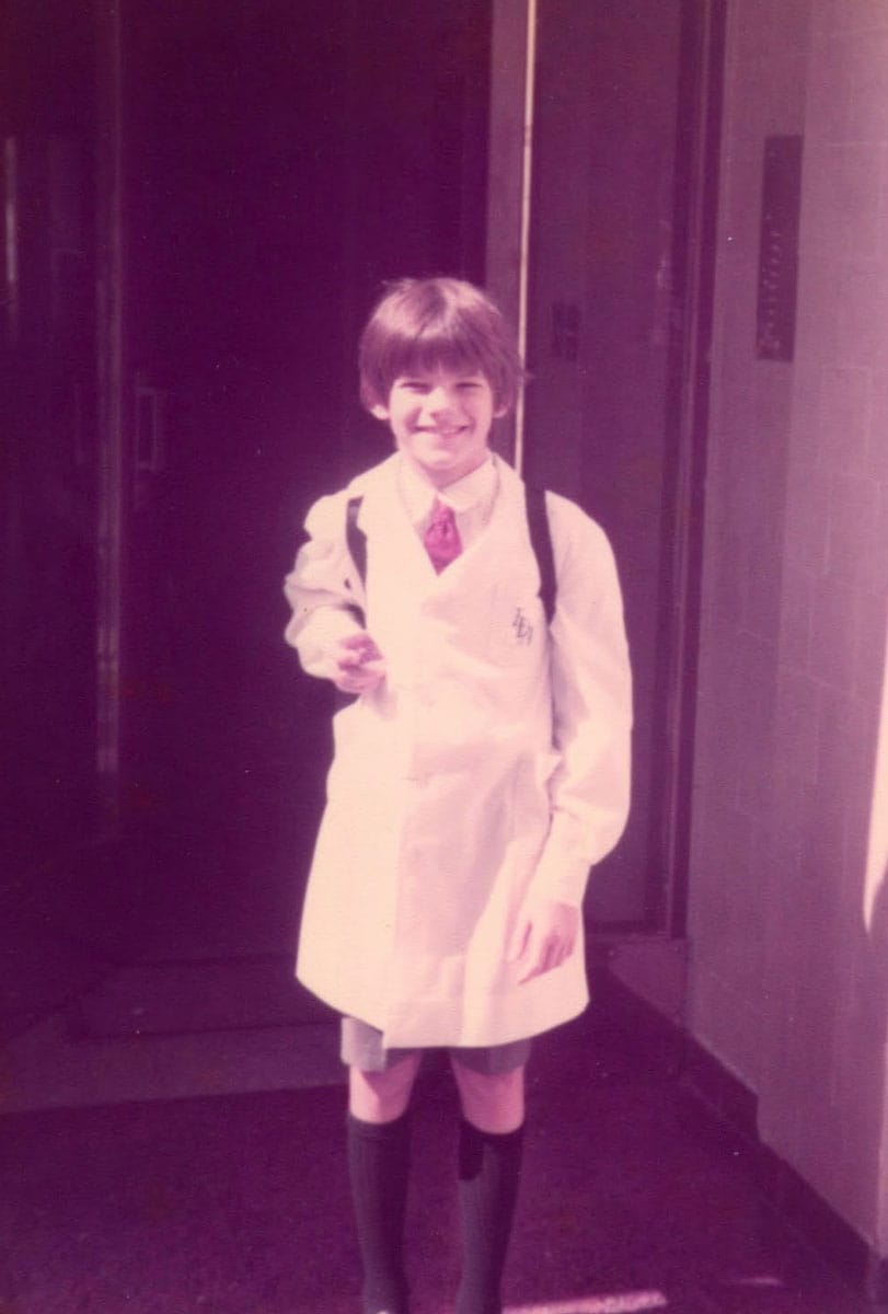 Luciano Marraffini as a child smiling in a white lab coat.