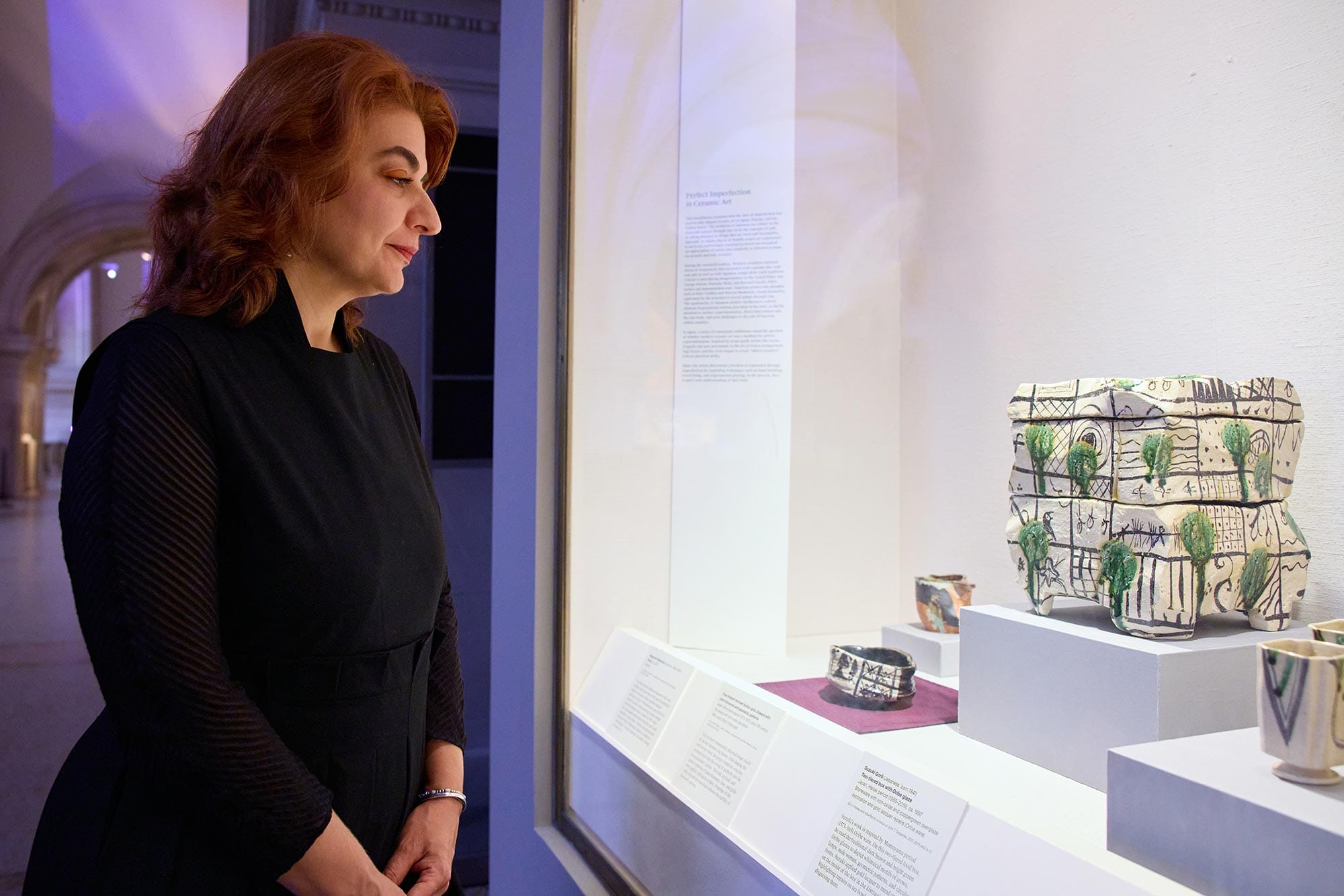 Monika Bincsik looking into an art exhibition display case.