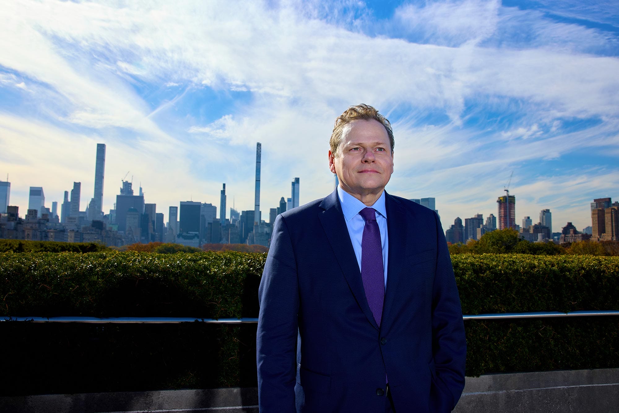 Wolfram Koeppe standing on a rooftop with the New York City skyline behind him. 