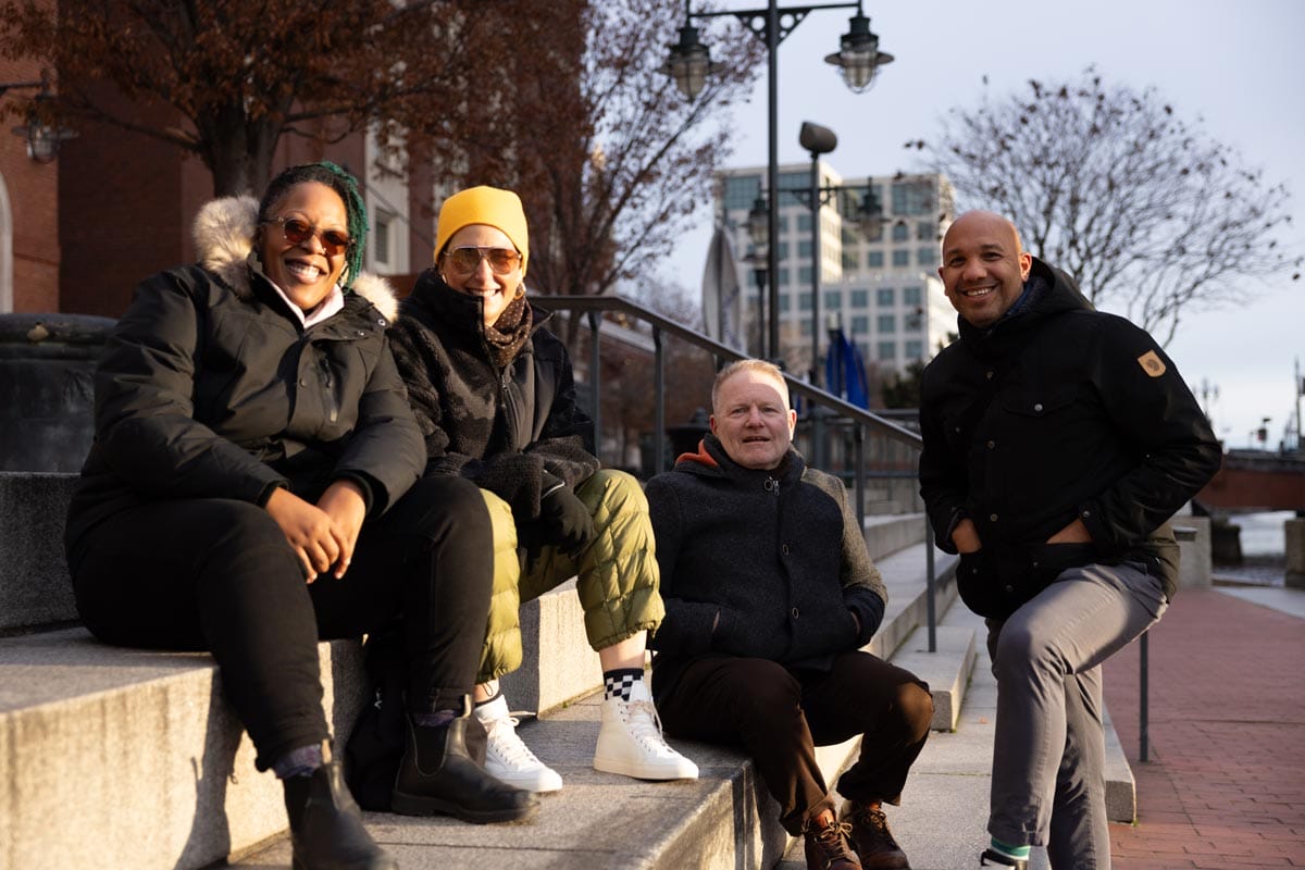 Ramon Tejada poses for a photo outdoors alongside three of his colleagues.