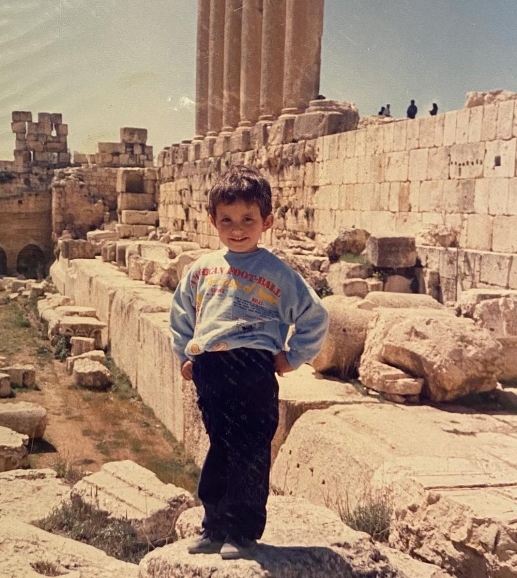 An old photo of Wael Morcos as a small child standing in front of ruins. 