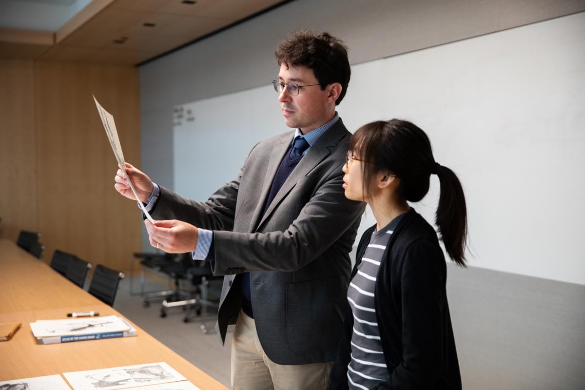 Tomasz Nowakowski reading a paper with a colleague.