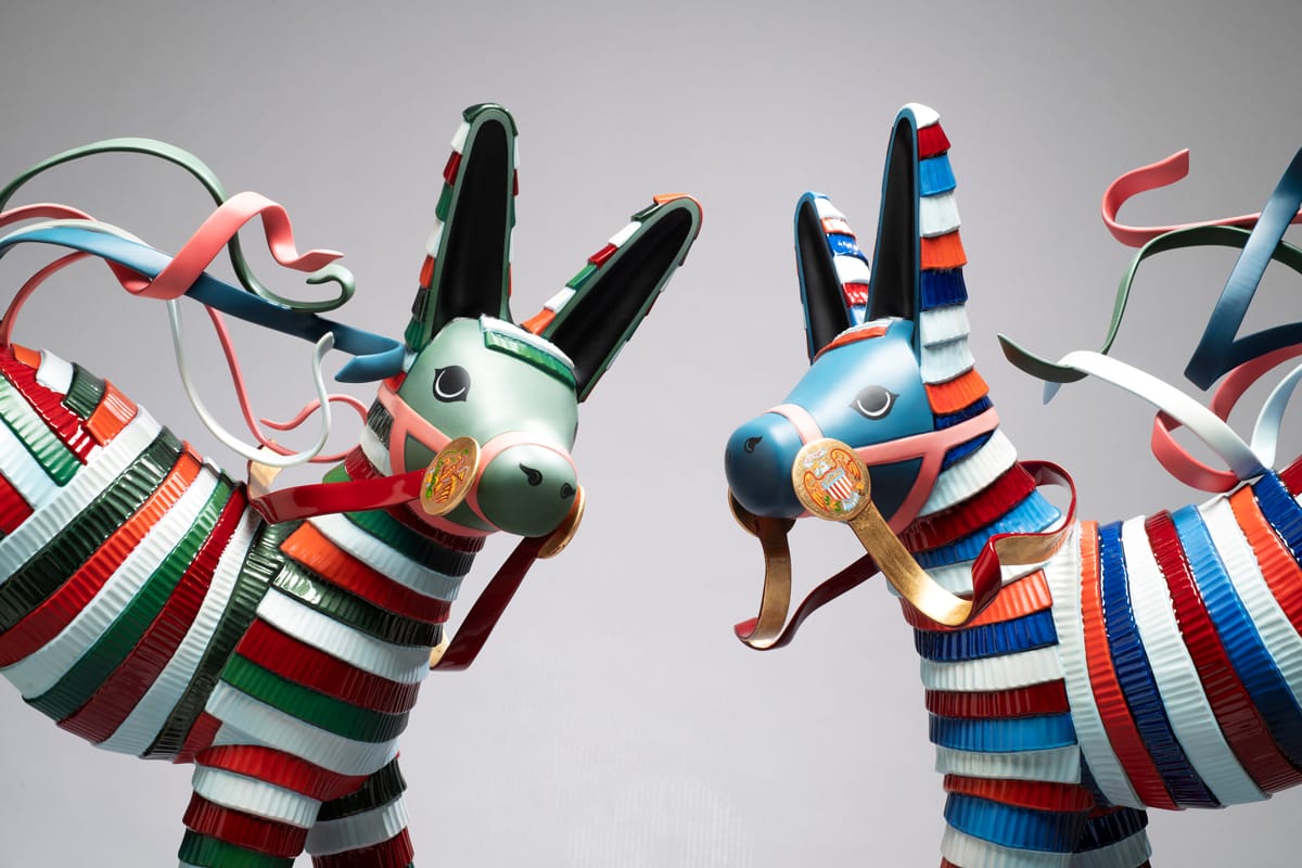 A close-up shot of two multicolor piñata-inspired donkey sculptures with detailed reins.