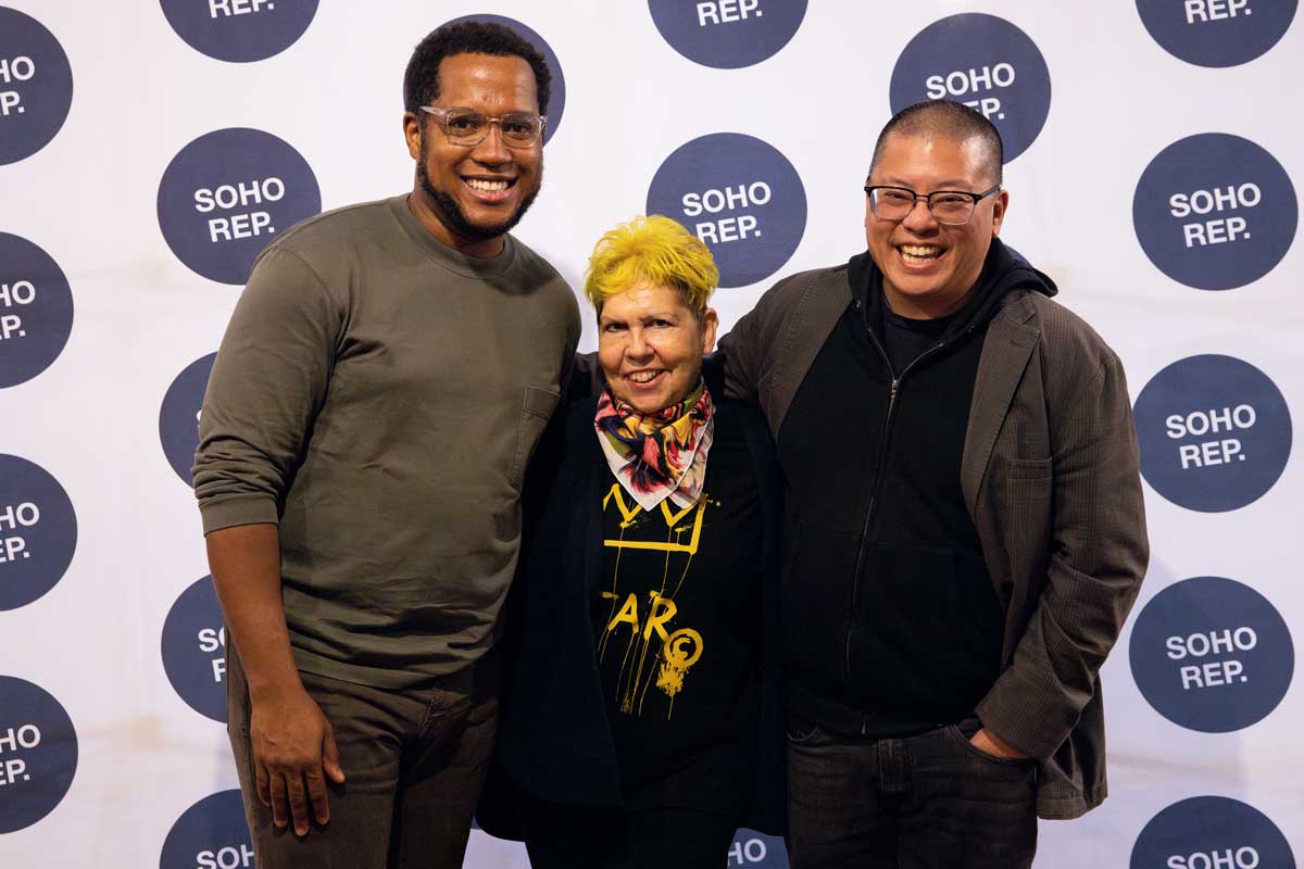 Three people stand in front of the "step and repeat" at SoHo Rep.