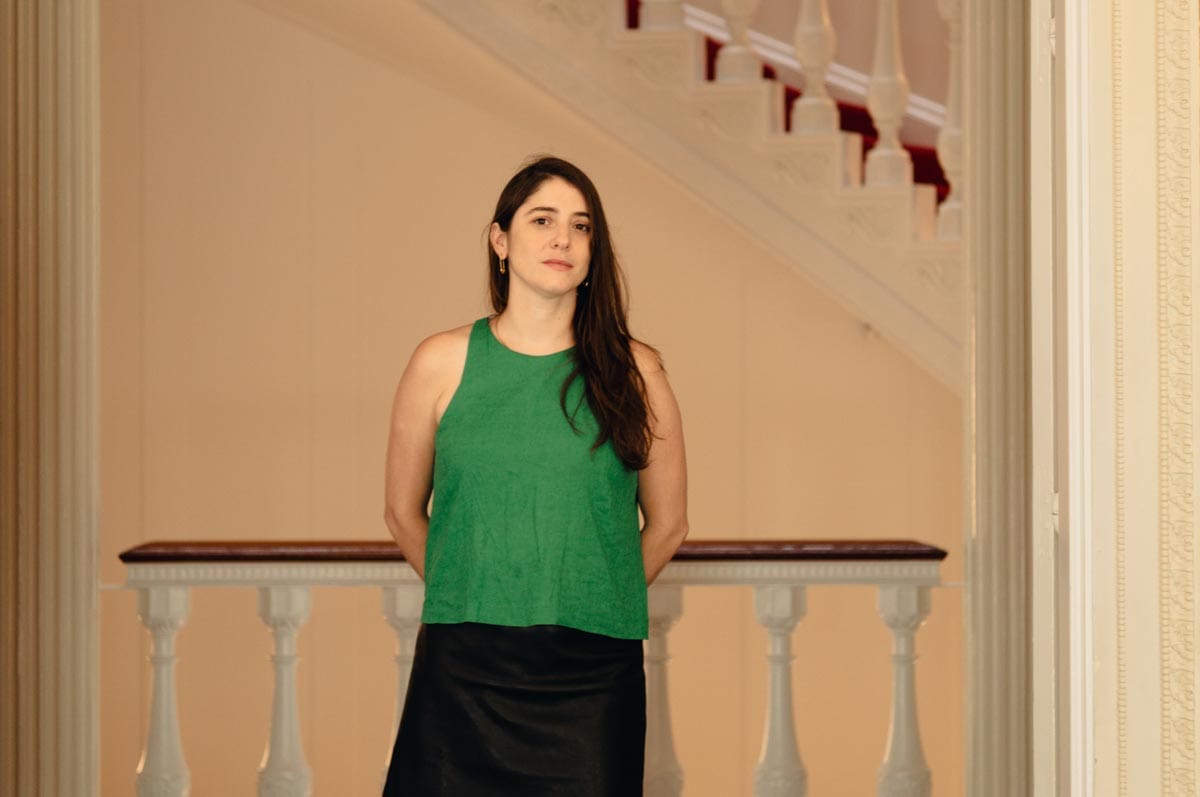 Aimé standing in front of an ornate wooden banister.