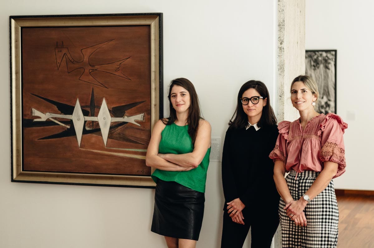 Aimé and two of her colleagues pictured next to an artwork in a gallery.