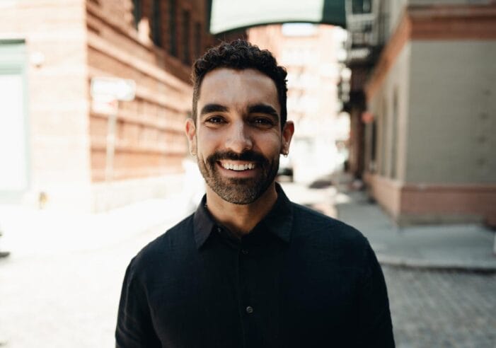 Bernardo stands on the New York City streets with city architecture visible behind him.