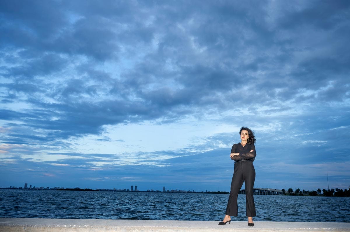 Donna posing as she stands on a boardwalk overlooking the Atlantic Ocean.