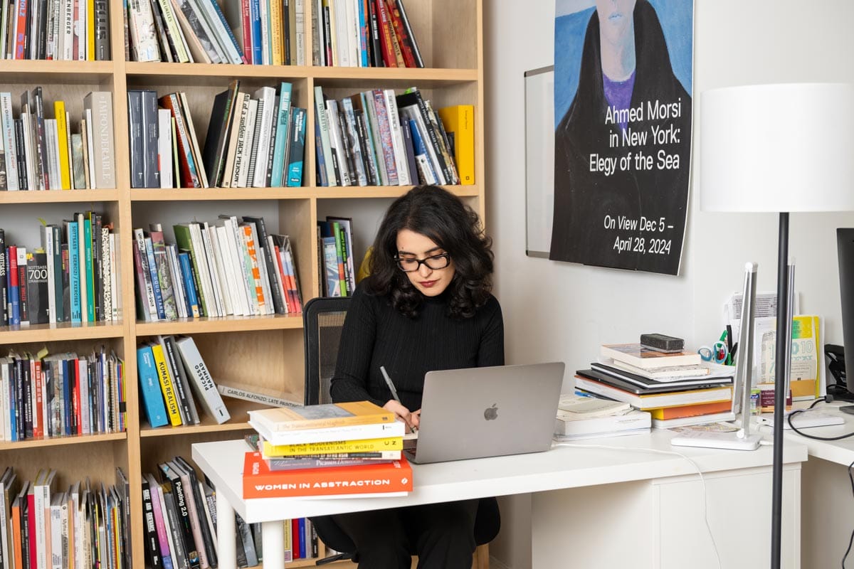 Donna seated at her desk working from a laptop.