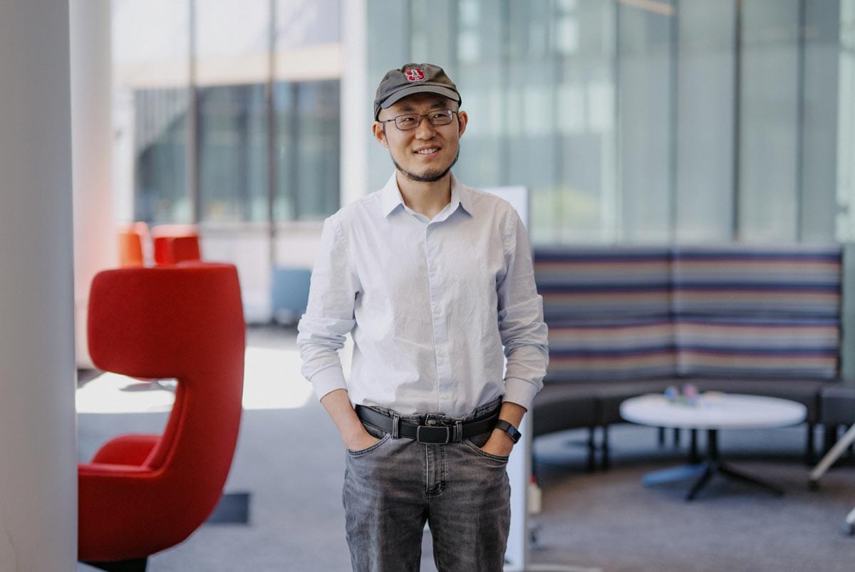 Guosong standing and posing for a portrait in a student lounge.