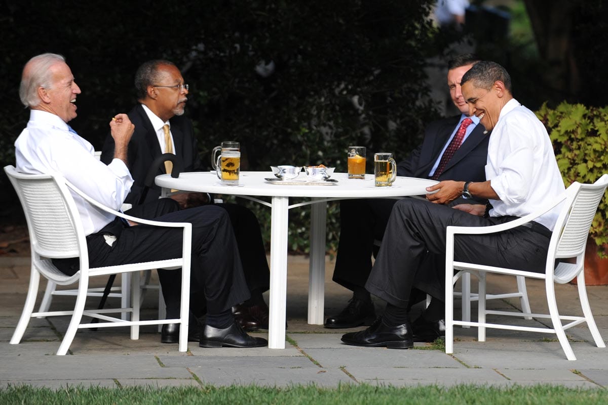 Henry Louis Gates Jr., Joe Biden, and Barack Obama sitting at a table enjoying a conversation.