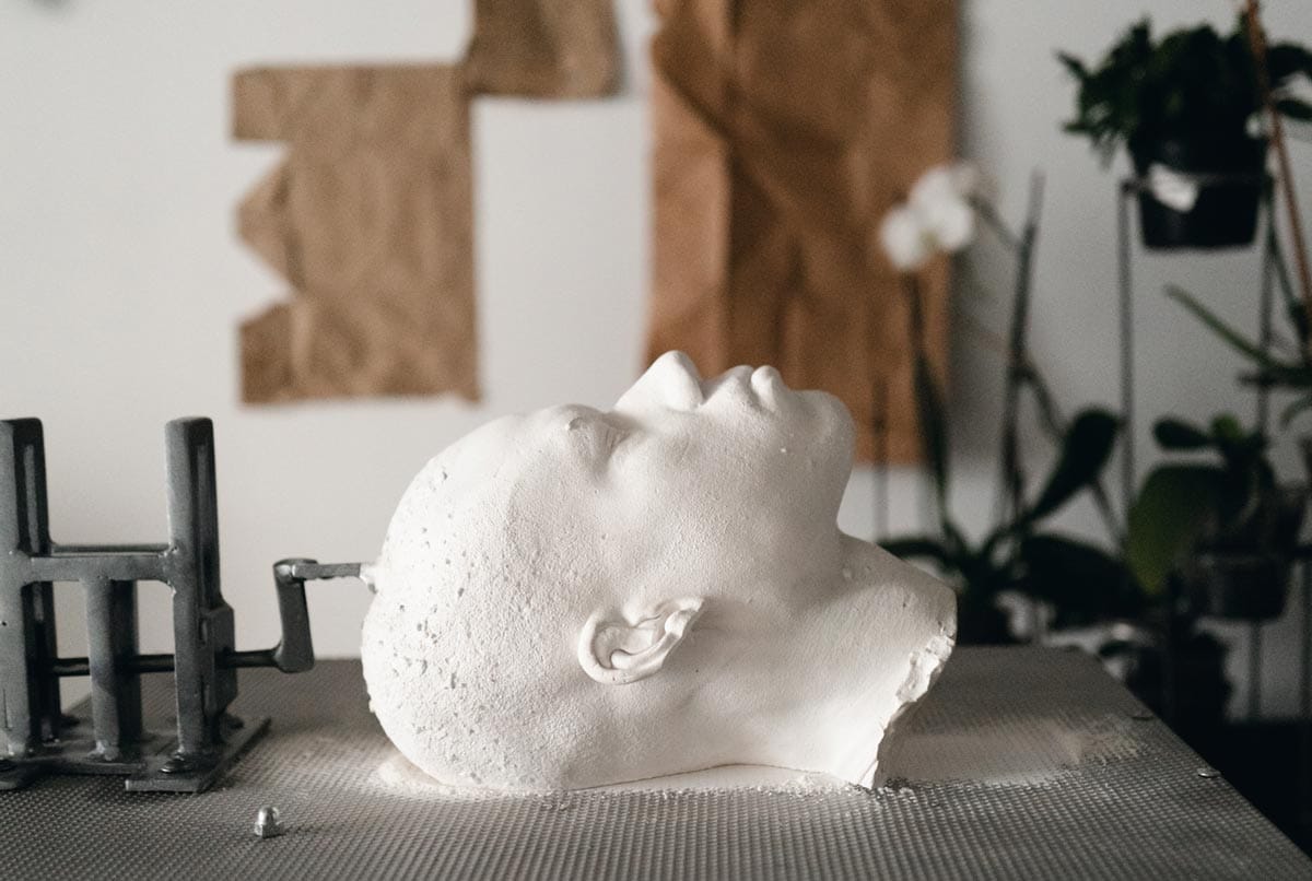 A white cast of Jeffrey's head lying on a table in his studio.