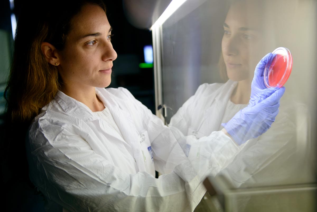 Maayan holding up a red sample in a petri dish.