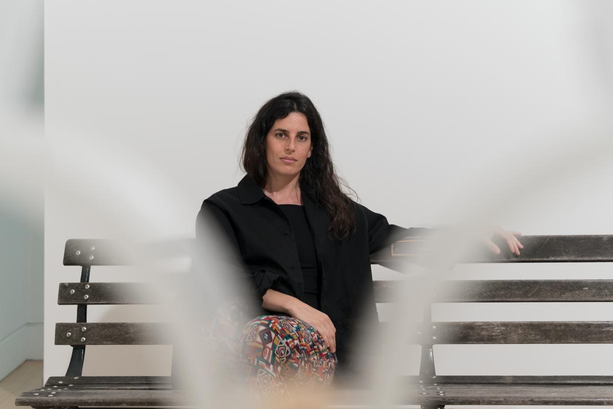 Selva sitting on a bench with a metal frame in front of her.