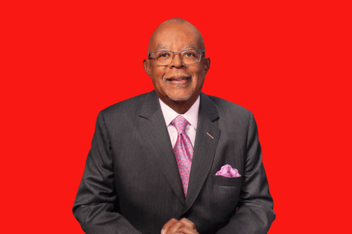 A portrait of Henry Louis Gates Jr. against a red background.