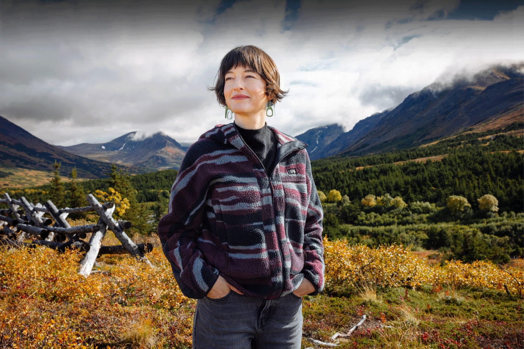 Francesca Du Brock standing in nature in Alaska with the fall colors behind her.