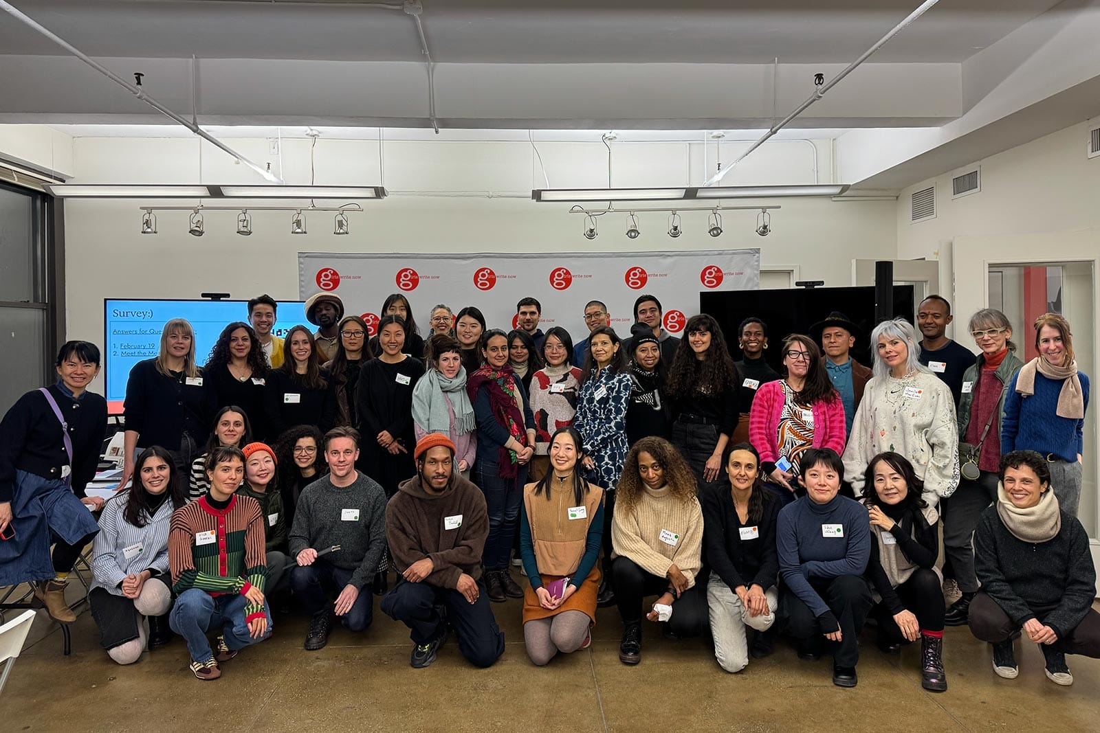 A large, diverse group of people, some standing and some kneeling, pose for a group photo.