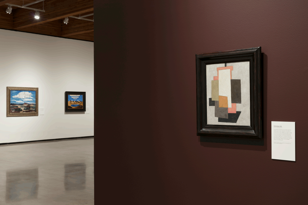 Marsden Hartley exhibition still: two paintings displayed on a white all (left) and Hartley's Provincetown displayed on a burgundy wall (right).